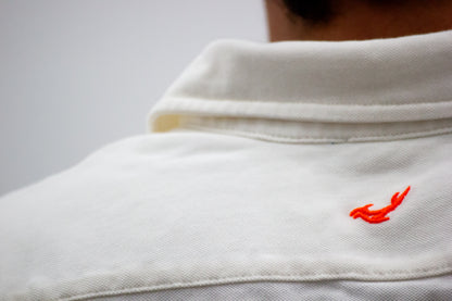Camisa piqué marfil bordado naranja